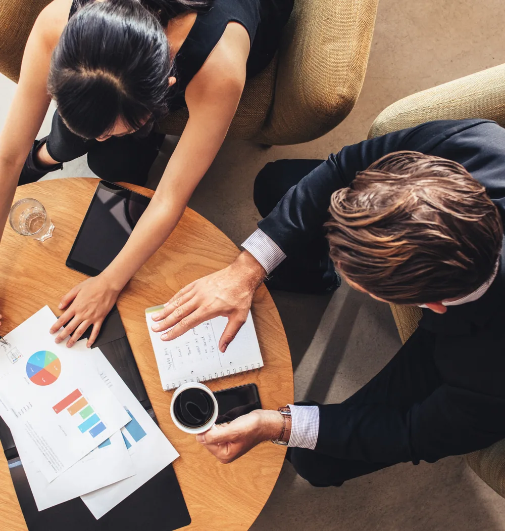 Vue de dessus de deux consultants SODIGIX analysant des graphiques